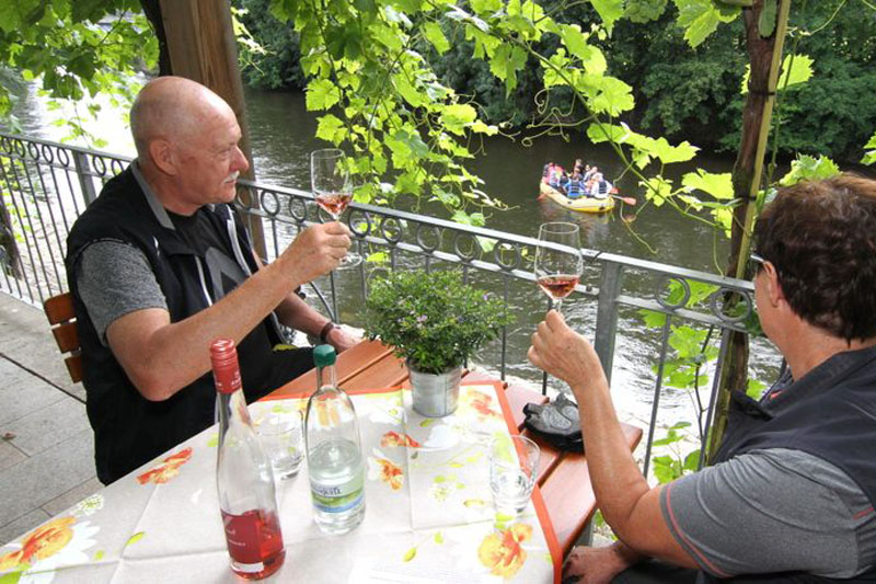  Zum Wohl: Mit einem Blick auf die Schlauchbootfahrer auf der Saale genießen wir den Rosé im Thüringer Weingut Zahn in Kaatschen.