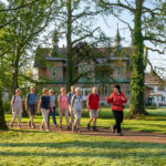 Geführte Wandergruppe im Kurpark Bad Sulza mit Guide vor historischem Gebäude