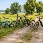 Drei E-Bikes auf einem Weg in sommerlicher Landschaft im Weimarer Land