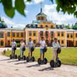 Gruppe von fünf Personen auf Segways vor Schloss Belvedere in Weimar
