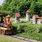 Kleine Eisenbahn fährt durch eine Miniatur-Burgenlandschaft im Burgenland Eckartsberga mit detailgetreuen Modellen von Schlössern und Türmen